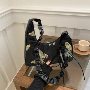 Elegant black canvas hobo bag with gold butterfly embroidery and scrunchie strap detail