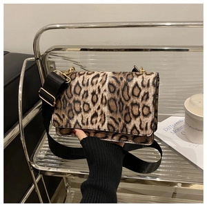 Detail of leopard print crossbody bag with adjustable black strap and gold buckle