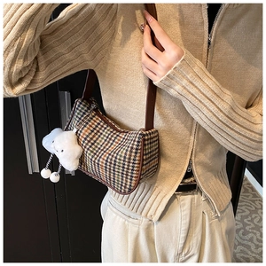 Close-up of retro plaid underarm bag with leather strap and cloud charm detail