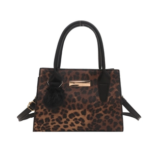 Sac à épaule léopard élégant avec détails dorés et pompon noir décoratif