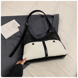 Detail of hobo tote bag featuring black leather and white faux fur pocket with buttons