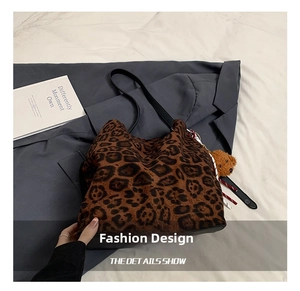 Detail of leopard print tote bag with plush bear charm and faux fur texture finish