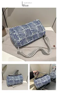 Detailed view of the blue geometric woven barrel bag with wide patterned shoulder strap