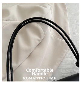 Detailed close-up of smooth black leather shoulder strap with premium stitching detail