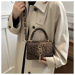 Détail du sac léopard avec boucle dorée entrelacée et pendentif à pampilles chic