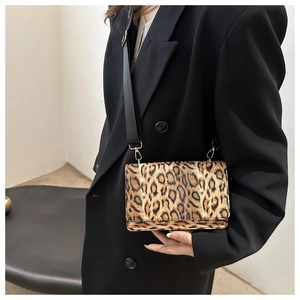 Schicke Umhängetasche mit Leopardenmuster und breitem schwarzem Gurt am Modell