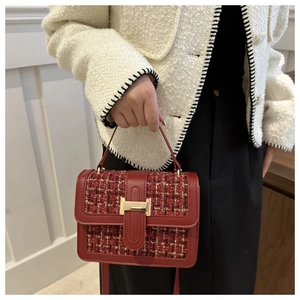 Detail of red tweed square bag with gold H-buckle and textured faux leather trim