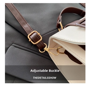 Detail of brown leather strap with golden adjustable buckle on off-white crossbody bag