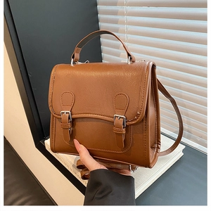 Detail of vintage brown pebble leather satchel with double buckle flap and silver hardware