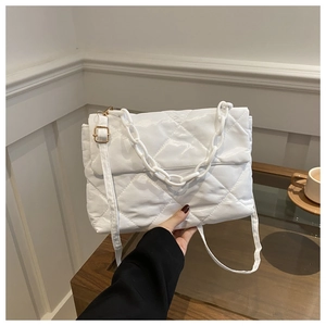 Detail of white quilted handbag with a chunky plastic chain and adjustable shoulder strap