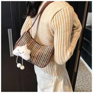Detail of retro plaid underarm bag with cute plush cloud charm and brown leather strap