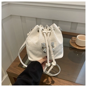 Chic white drawstring bucket bag with silver metal bow detail and embossed leather texture