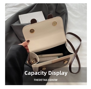 Detail view of the cream and brown crossbody bag interior showing daily storage capacity