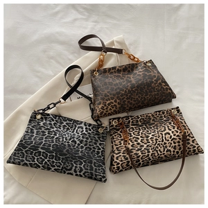 Détail de trois sacs à bandoulière imprimé léopard avec d'élégantes chaînes en résine