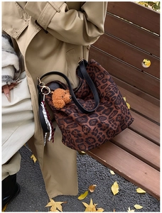 Detailed shot of leopard print tote bag with teddy bear charm and striped scarf detail
