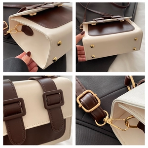 Detailed view of the contrast color handbag with golden metal feet and stitching details