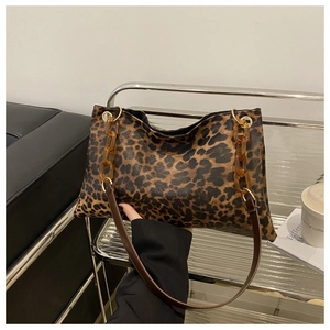 Detail of leopard print tote bag with amber acrylic chain and brown shoulder strap