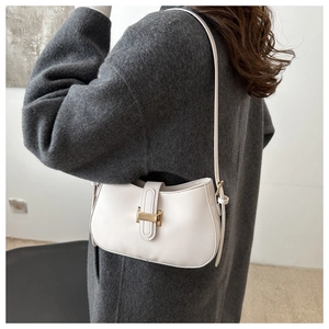 Minimalist white leather underarm bag featuring a golden H-shaped buckle on female model
