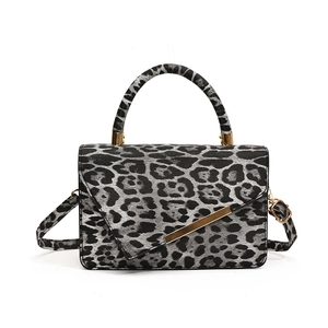 Chic leopard print crossbody bag with gold metal trim and structured top handle
