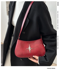 Détail d'un sac d'épaule vintage rouge en cuir avec une boucle étoilée argentée