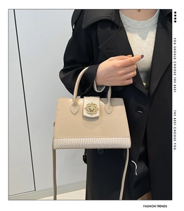 Detail of beige structured crossbody bag with animal texture and vintage gold buckle