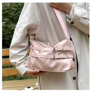 Detail der hellrosa Lackleder-Schultertasche mit dekorativen Metallschnallen-Riemen