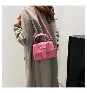 Model wearing rose pink square crossbody bag with gold buckle and adjustable strap