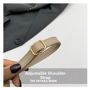 Macro detail of adjustable faux leather shoulder strap with gold-tone metal buckle