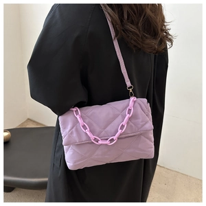 Détail du sac bandoulière violet matelassé avec chaîne épaisse et texture souple