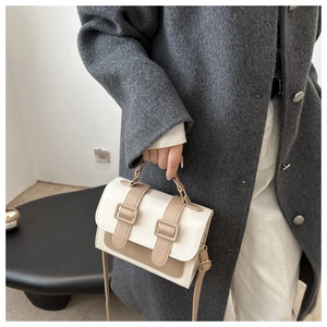 Detail of color-block mini bag featuring contrast straps and a premium textured finish