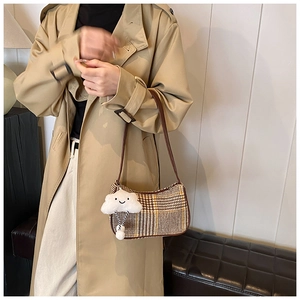 Detail of checkered plaid shoulder bag with soft cloud-shaped plush keychain accessory