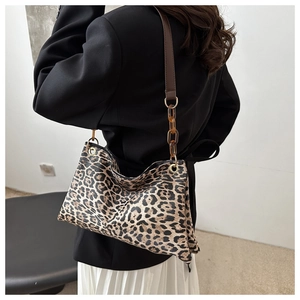 Détail du sac léopard avec bandoulière en cuir marron et maillons de chaîne ambrés
