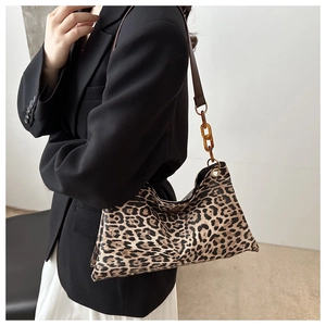 Détail du sac cabas à imprimé léopard avec une bandoulière chic en chaîne ambre