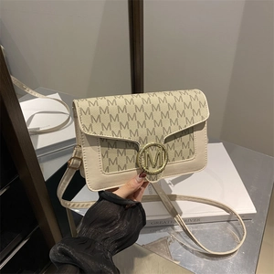 Sac à bandoulière beige imprimé de lettres avec boucle M dorée porté main