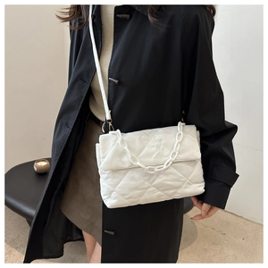 Gros plan du sac bandoulière blanc matelassé avec chaîne en résine et lanière en cuir