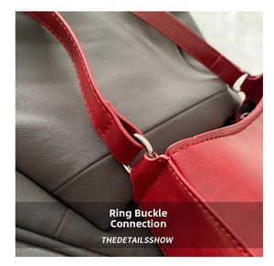 Détail du sac rouge en cuir montrant le connecteur argenté et les coutures précises