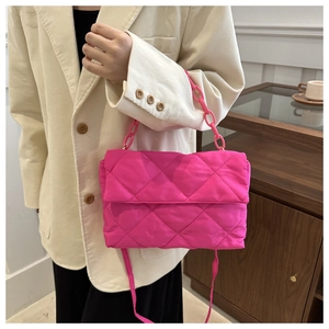 Detail of rose pink quilted chain bag with nylon texture on white corduroy outfit