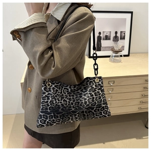 Détail de la texture léopard et de la bandoulière en chaîne noire sur un sac cabas