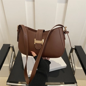 Retro brown saddle bag with golden H-buckle shown against a minimalist background