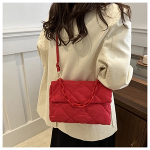 Détail du sac bandoulière matelassé rouge avec chaîne épaisse et texture en nylon