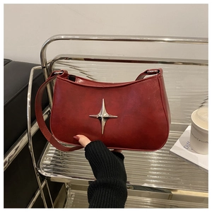 Détail du sac à bandoulière rouge foncé vintage avec étoile en argent et texture cuir ciré