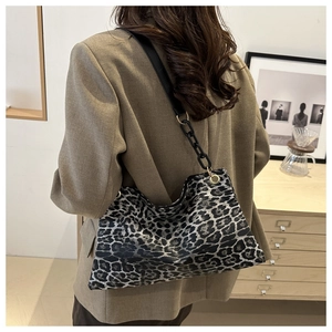 Chic leopard print shoulder bag with black chain strap shown on model in khaki blazer