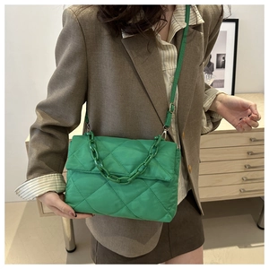 Détail d'un sac bandoulière vert matelassé avec chaîne résine et nylon