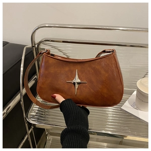 Détail d'un sac à bandoulière en cuir marron avec boucle métallique en forme d'étoile