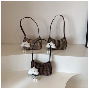 Detailed display of three plaid underarm bags with plush cloud charms on a white stand