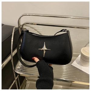 Détail du sac à bandoulière demi-lune noir avec emblème étoile argenté et fini brillant
