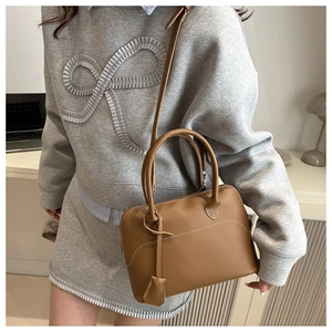Dettaglio borsa Boston vintage in pelle marrone opaca con cuciture bianche e tracolla