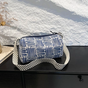 Artistic blue and white striped knit cylindrical shoulder bag with wide pattern strap
