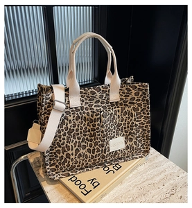 Detail of leopard print tote bag featuring dual front pockets and durable strap