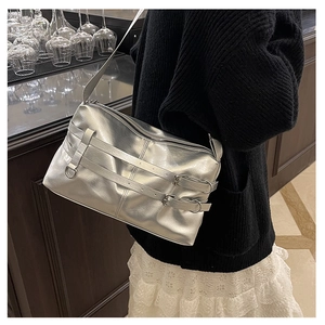 Detail of silver metallic shoulder bag with stylish double belt buckles and smooth zipper